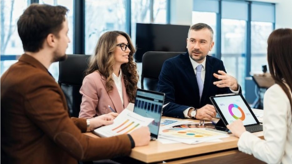 Business people discussing reports that are on their laptops